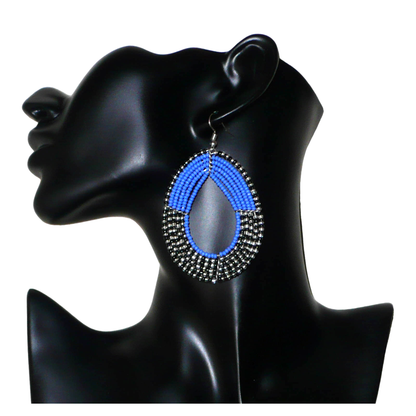 Longues boucles d'oreilles multi-rangs composées de perles de rocaille bleues, noires et gris nacré ; elles mesurent 8 cm de long et 5 cm de large et se portent avec des crochets sur des oreilles percées.