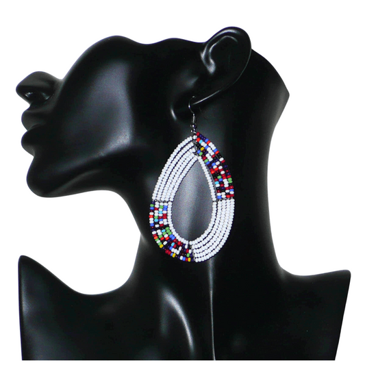 Longues boucles d'oreilles multi-rangs en forme de gouttes faites de perles de rocaille blanches et multicolores fixées sur cinq rangées de fils de fer. Elles mesurent 9 cm de de long et 4,5 cm de large et se portent sur des oreilles percées.
