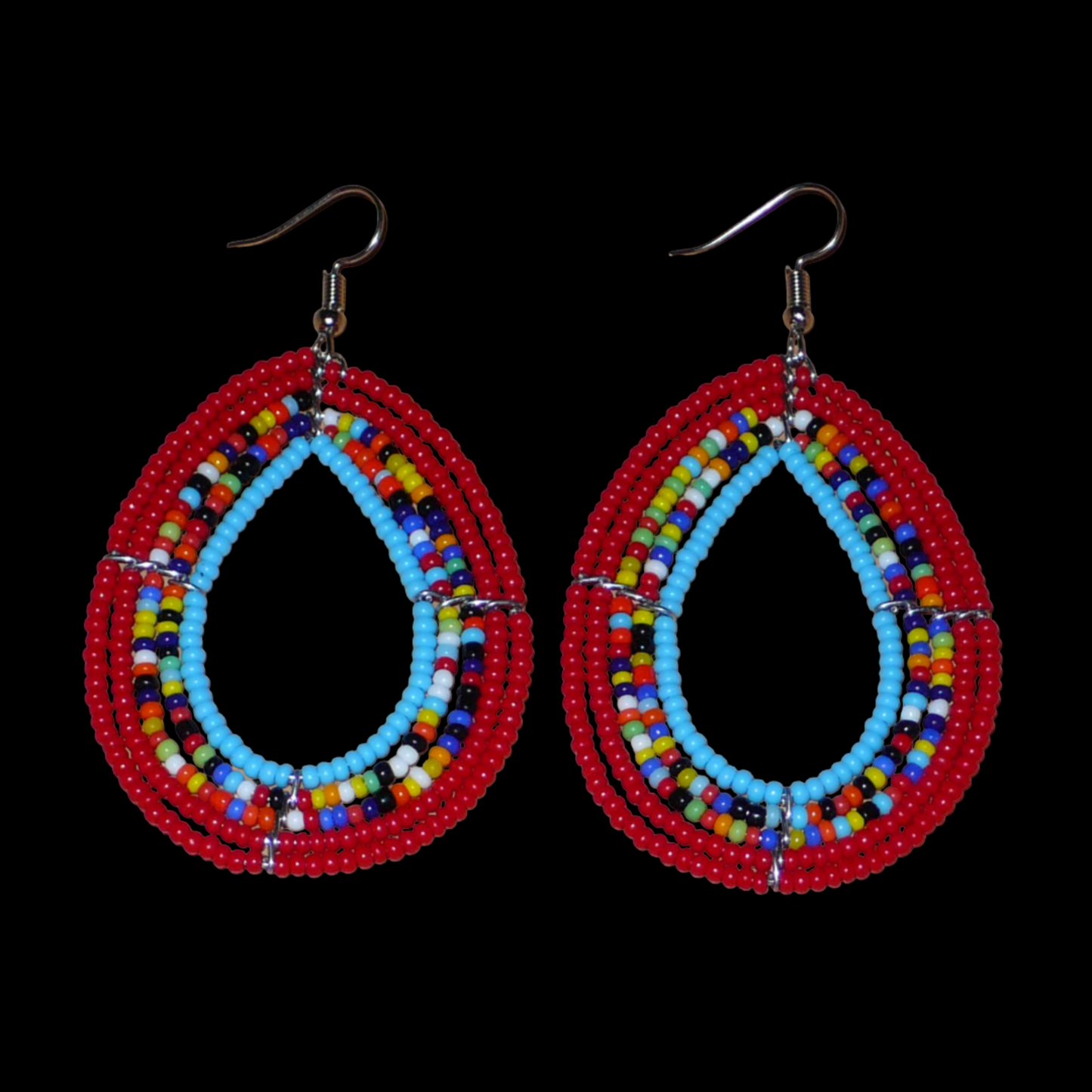 Boucles d'oreilles en forme de gouttes faites de perles de rocaille rouges, bleues et multicolores. Elles mesurent 7,5 cm de long et 4 cm de large et se portent sur des oreilles percées.