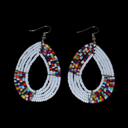 Boucles d'oreilles kenyanes en perles de rocaille blanches et multicolores enfilées sur plusieurs rangs de fils de fer montées en forme de gouttes ovales. De taille moyenne, ces boucles d'oreilles mesurent 7,5 cm de long et 4 cm de large, et se portent avec crochets en acier inoxydable sur des oreilles percées.