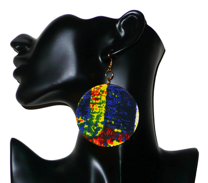 Boucles d'oreilles rondes composées de tissu à motifs africains bleus, jaunes, orange, noirs et vert drapé sur une structure circulaire en plastique. Longues, larges, mais légères à porter, ces boucles d'oreilles mesurent 9 cm de long et 6 cm de large.