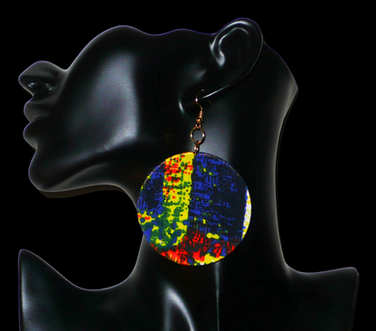 Boucles d'oreilles rondes composées de tissu à motifs africains bleus, jaunes, orange, noirs et vert drapé sur une structure circulaire en plastique. Longues, larges, mais légères à porter, ces boucles d'oreilles mesurent 9 cm de long et 6 cm de large. 