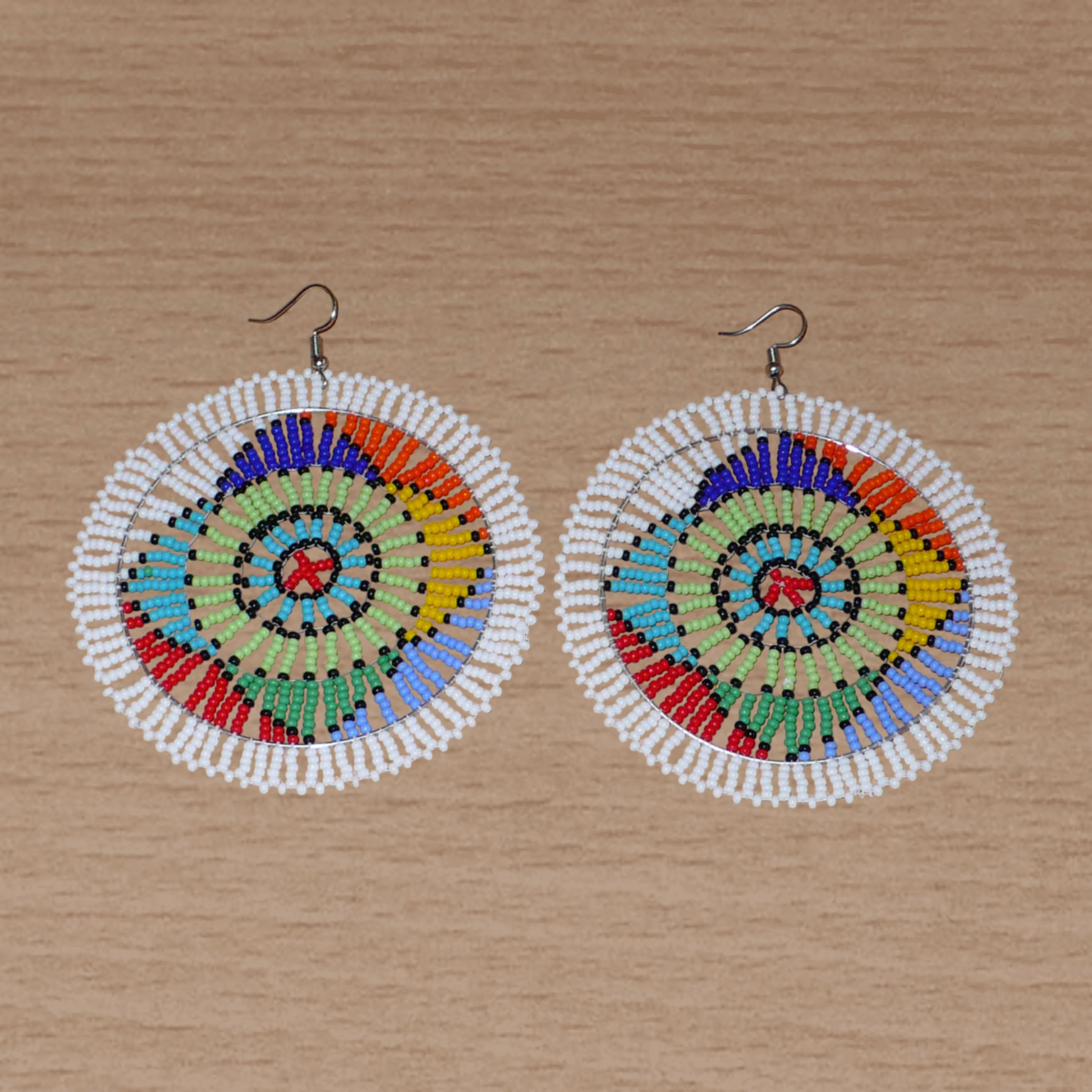 Boucles d'oreilles africaines à motifs ethniques sud-africains composées de perles de rocaille blanches et multicolores. Surdimensionnées, elles mesurent 10 cm de long et 8.5 cm de large.