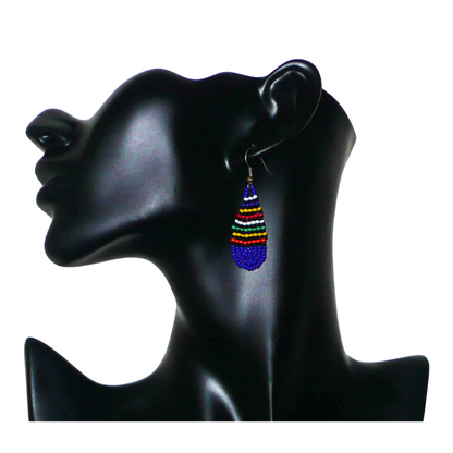 Petites boucles d'oreilles sud-africaines de tradition ethnique zouloue composée d'un tissage de perles de rocaille bleu foncé et multicolores. Cette paire de boucles d'oreilles traditionnelles mesure 5.5 cm de long et 2 cm de large, et se portent avec des crochets en acier inoxydable sur des oreilles percées.