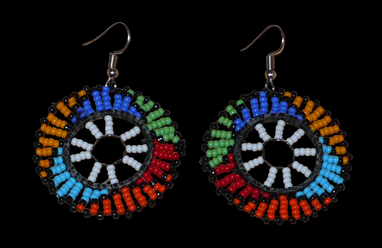 Boucles d'oreilles ethniques rondes à motifs sud-africains zoulous composées de perles de rocaille blanches et multicolores. De taille moyenne et légères à porter, elles mesurent 6 cm de long et 4 cm de large, et se portent sur des oreilles percées.