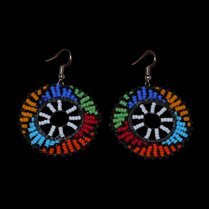 Boucles d'oreilles ethniques rondes à motifs sud-africains zoulous composées de perles de rocaille blanches et multicolores. De taille moyenne et légères à porter, elles mesurent 6 cm de long et 4 cm de large, et se portent sur des oreilles percées.