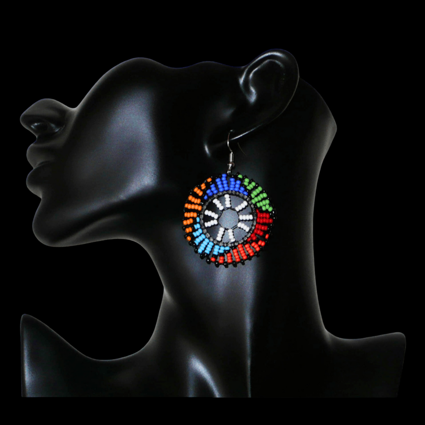 Boucles d'oreilles ethniques rondes à motifs sud-africains zoulous composées de perles de rocaille blanches et multicolores. De taille moyenne et légères à porter, elles mesurent 6 cm de long et 4 cm de large, et se portent sur des oreilles percées.