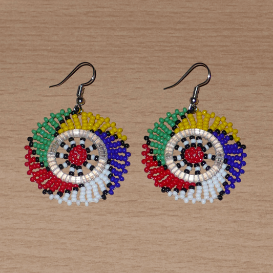 Boucles d'oreilles sud-africaines rondes à motifs traditionnels zoulous faites de perles de rocaille multicolores. Elles mesurent 6 cm de long et 4 cm de large et se portent sur des oreilles percées.