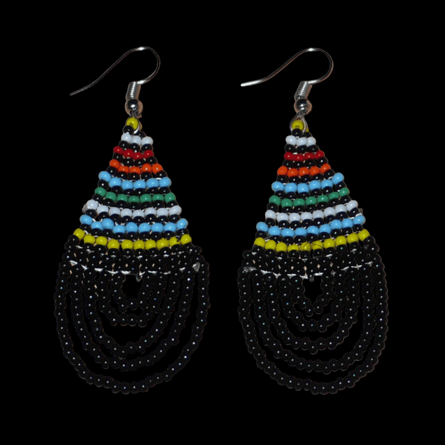Boucles d'oreilles ethniques de tradition sud-africaine en forme de gouttes composées d'un tissage de perles de rocaille noires et multicolores. Elles mesurent 7 cm de long et 2,5 cm de large et se portent sur des oreilles percées.