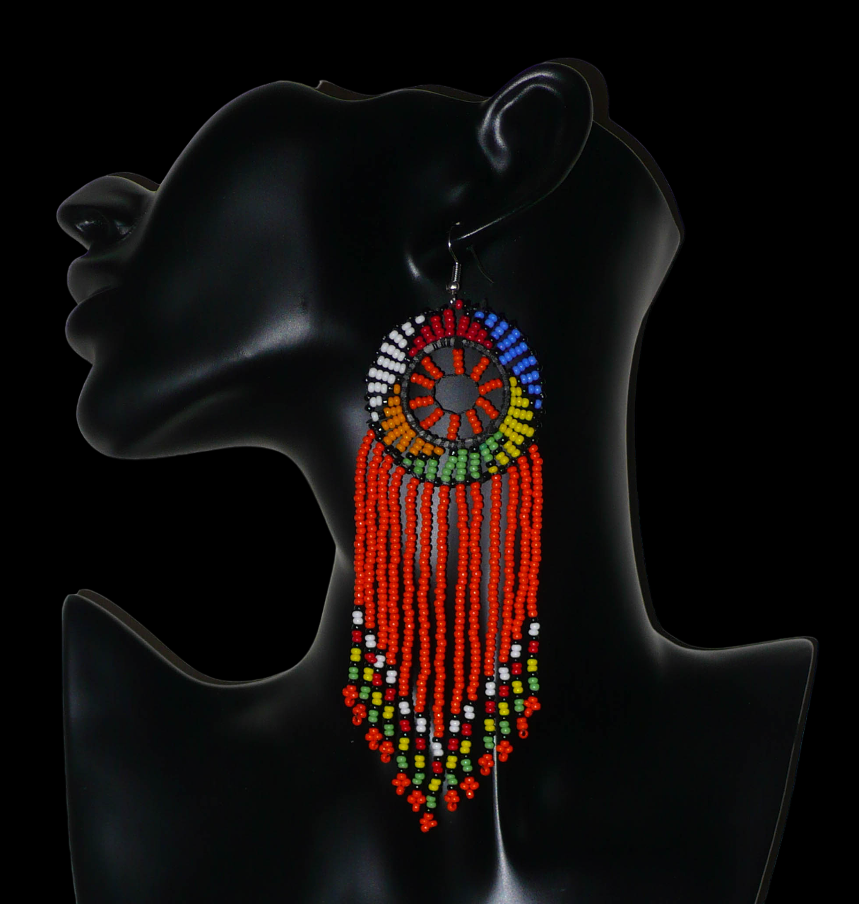 Longues boucles d'oreilles sud-africaines à franges et motifs traditionnels zoulous composées de perles de rocaille orange et multicolores. Elles mesurent 14,5 cm de long et 4,5 cm de large.