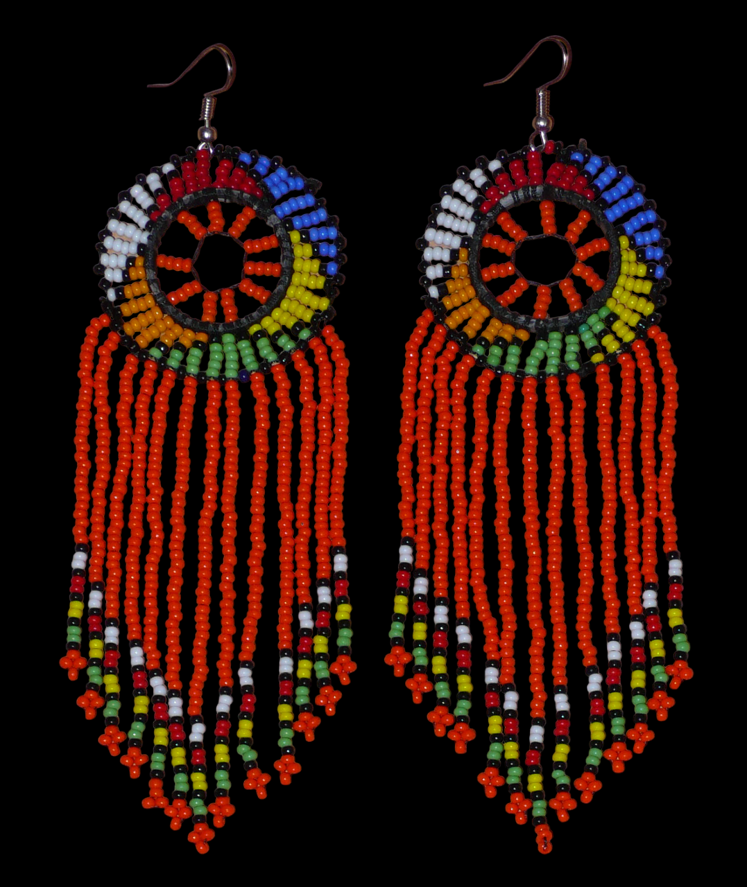 Longues boucles d'oreilles sud-africaines à franges et motifs traditionnels zoulous composées de perles de rocaille orange et multicolores. Elles mesurent 14,5 cm de long et 4,5 cm de large.