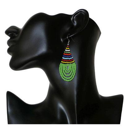 Boucles d'oreilles africaines traditionnelles zouloues en forme de gouttes faites d'un tissage de perles de rocaille vertes et multicolores. Elles mesurent 7 cm de long et 2,5 cm de large et se portent sur des oreilles percées. 