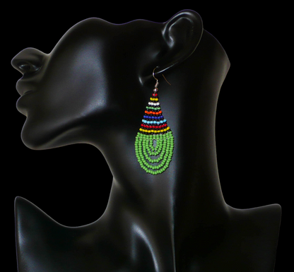 Boucles d'oreilles africaines de tradition zouloue en forme de gouttes composées d'un tissage de perles de rocaille vertes et multicolores. Elles mesurent 7 cm de long et 2,5 cm de large et se portent sur des oreilles percées. Timeless Fineries