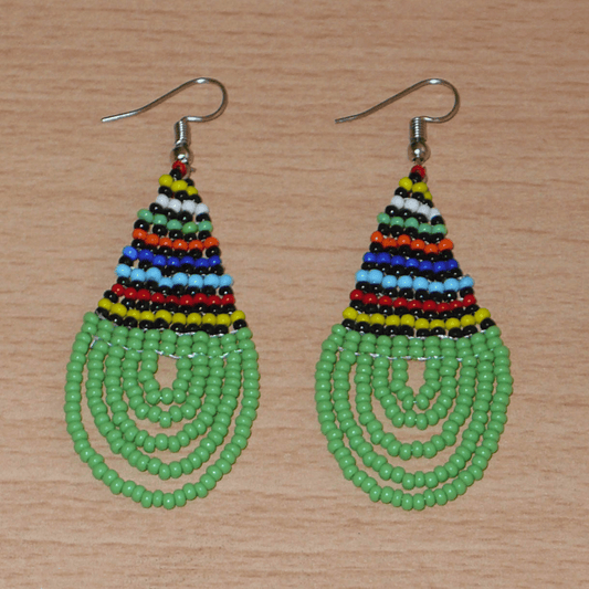 Boucles d'oreilles africaines traditionnelles zouloues en forme de gouttes faites d'un tissage de perles de rocaille vertes et multicolores. Elles mesurent 7 cm de long et 2,5 cm de large et se portent sur des oreilles percées. 