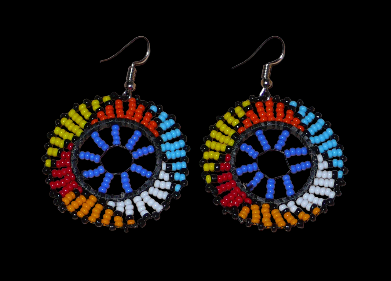 Boucles d'oreilles africaines rondes à motifs ethniques zoulous composées de perles de rocaille bleues et multicolores. De taille moyenne et légères à porter, elles mesurent 6 cm de long et 4 cm de large. Elles se portent avec des crochets en acier inoxydable sur des oreilles percées.