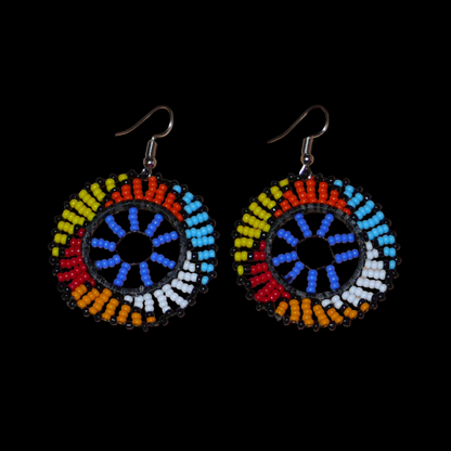 Boucles d'oreilles africaines rondes à motifs ethniques zoulous composées de perles de rocaille bleues et multicolores. De taille moyenne et légères à porter, elles mesurent 6 cm de long et 4 cm de large. Elles se portent avec des crochets en acier inoxydable sur des oreilles percées.