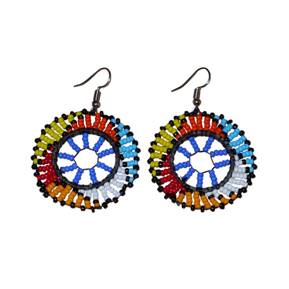 Boucles d'oreilles africaines rondes à motifs ethniques zoulous composées de perles de rocaille bleues et multicolores. De taille moyenne et légères à porter, elles mesurent 6 cm de long et 4 cm de large. Elles se portent avec des crochets en acier inoxydable sur des oreilles percées.