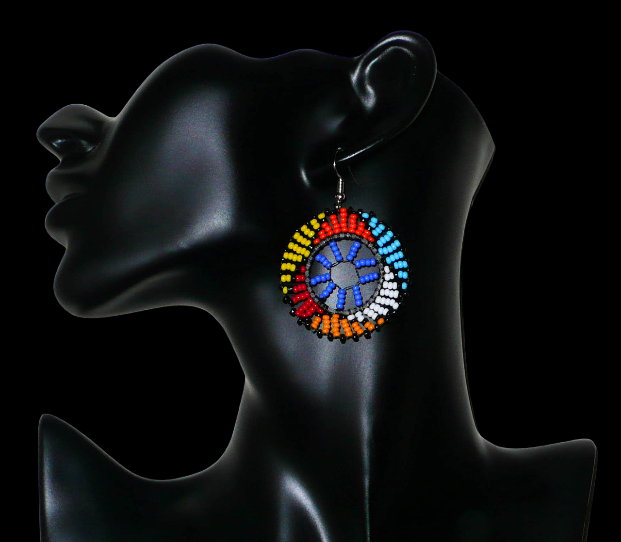 Boucles d'oreilles africaines rondes à motifs ethniques zoulous composées de perles de rocaille bleues et multicolores. De taille moyenne et légères à porter, elles mesurent 6 cm de long et 4 cm de large. Elles se portent avec des crochets en acier inoxydable sur des oreilles percées.