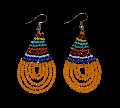 Boucles d'oreilles africaines traditionnelles en forme de gouttes composées d'un tissage de perles de rocaille orange et multicolores. Elles mesurent 7 cm de long et 2,5 cm de large. 