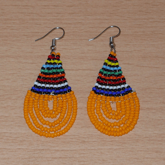Boucles d'oreilles africaines traditionnelles en forme de gouttes composées d'un tissage de perles de rocaille orange et multicolores. Elles mesurent 7 cm de long et 2,5 cm de large. 