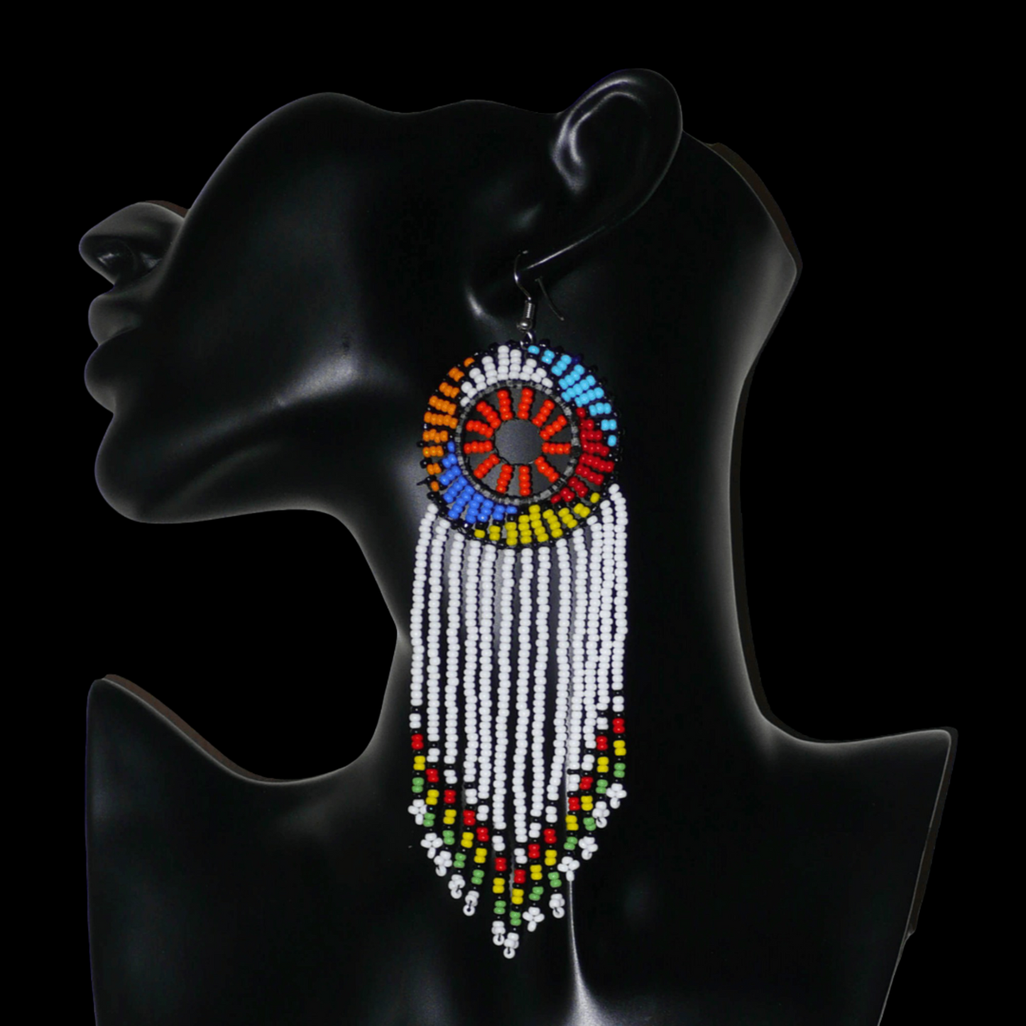 Longues boucles d'oreilles sud-africaines à franges et motifs traditionnels zoulous composées de perles de rocaille blanches, orange et multicolores. Elles mesurent 14,5 cm de long et 4,5 cm de large, et se portent avec des crochets en acier inoxydable sur des oreilles percées.