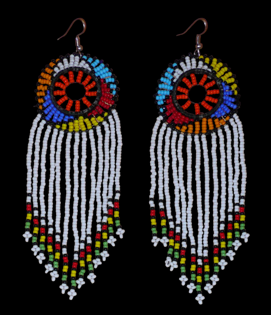 Longues boucles d'oreilles sud-africaines à franges et motifs traditionnels zoulous composées de perles de rocaille blanches, orange et multicolores. Elles mesurent 14,5 cm de long et 4,5 cm de large, et se portent avec des crochets en acier inoxydable sur des oreilles percées.