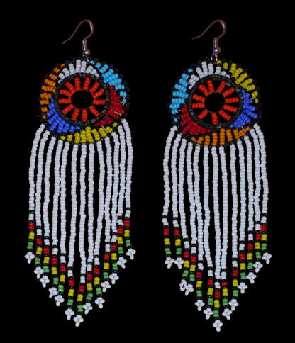 Longues boucles d'oreilles sud-africaines à franges et motifs traditionnels zoulous composées de perles de rocaille blanches, orange et multicolores. Elles mesurent 14,5 cm de long et 4,5 cm de large, et se portent avec des crochets en acier inoxydable sur des oreilles percées.