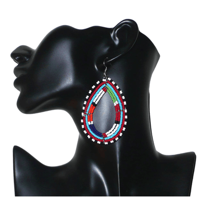 Boucles d'oreilles africaines à motifs ethniques Massai faites de perles de rocaille multicolores montées en forme de gouttes. Elles mesurent 8,5 cm de long et 4,5 cm de large et se portent sur des oreilles percées.