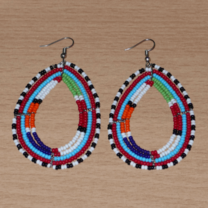 Boucles d'oreilles africaines à motifs ethniques Massai faites de perles de rocaille multicolores montées en forme de gouttes. Elles mesurent 8,5 cm de long et 4,5 cm de large et se portent sur des oreilles percées.