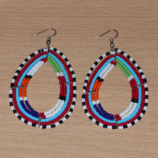 Boucles d'oreilles africaines à motifs ethniques Massai faites de perles de rocaille multicolores montées en forme de gouttes. Elles mesurent 8,5 cm de long et 4,5 cm de large et se portent sur des oreilles percées.