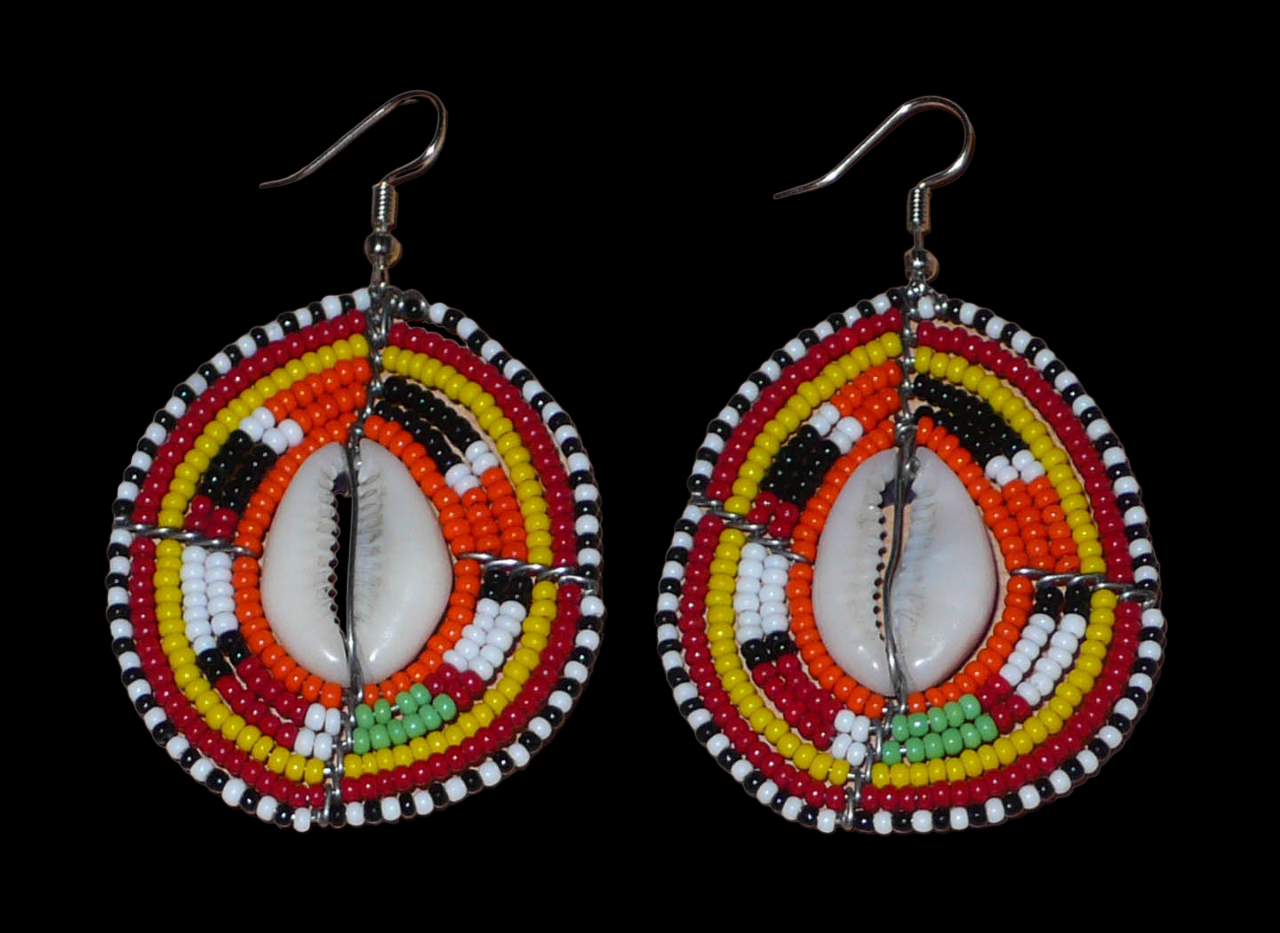 Boucles d'oreilles africaines en forme de boucliers Massai composées de perles et de coquillages. Elles mesurent 7 cm de long et 4 cm de large et se portent sur des oreilles percées.