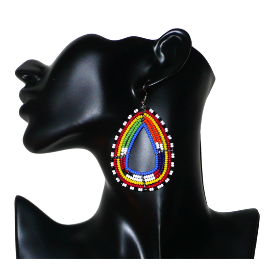Boucles d'oreilles tribales Massai bleues et multicolores faites de perles de rocaille montées en forme de gouttes légèrement triangulaires. Elles mesurent 8 cm de long et 4.5 cm de large et se portent sur des oreilles percées.