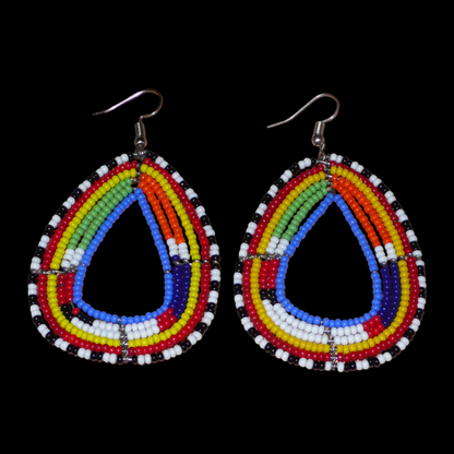 Boucles d'oreilles tribales Massai bleues et multicolores faites de perles de rocaille montées en forme de gouttes légèrement triangulaires. Elles mesurent 8 cm de long et 4.5 cm de large et se portent sur des oreilles percées.