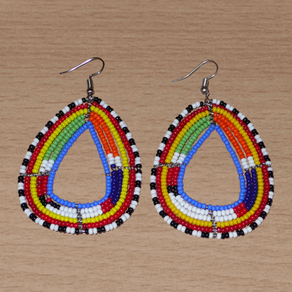 Boucles d'oreilles tribales Massai bleues et multicolores faites de perles de rocaille montées en forme de gouttes légèrement triangulaires. Elles mesurent 8 cm de long et 4.5 cm de large et se portent sur des oreilles percées.