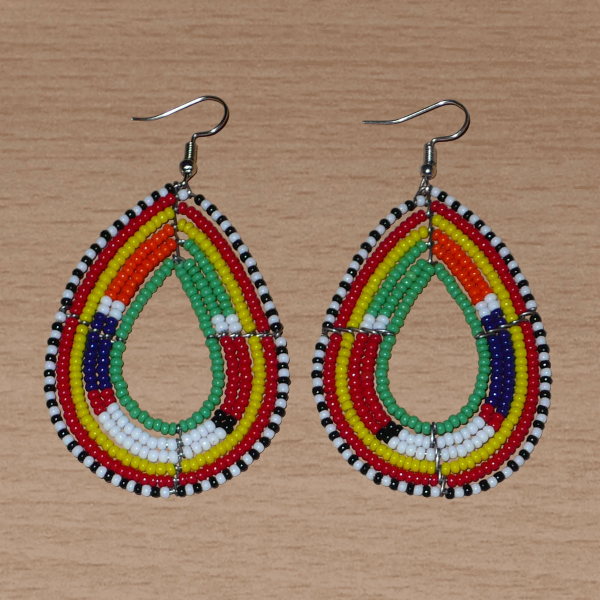 Boucles d'oreilles africaines Massai en forme de gouttes composées de perles vertes et multicolores ; elles mesurent 7,5 cm de long et 4 cm de large et se portent avec des crochets en acier inoxydable sur des oreilles percées.