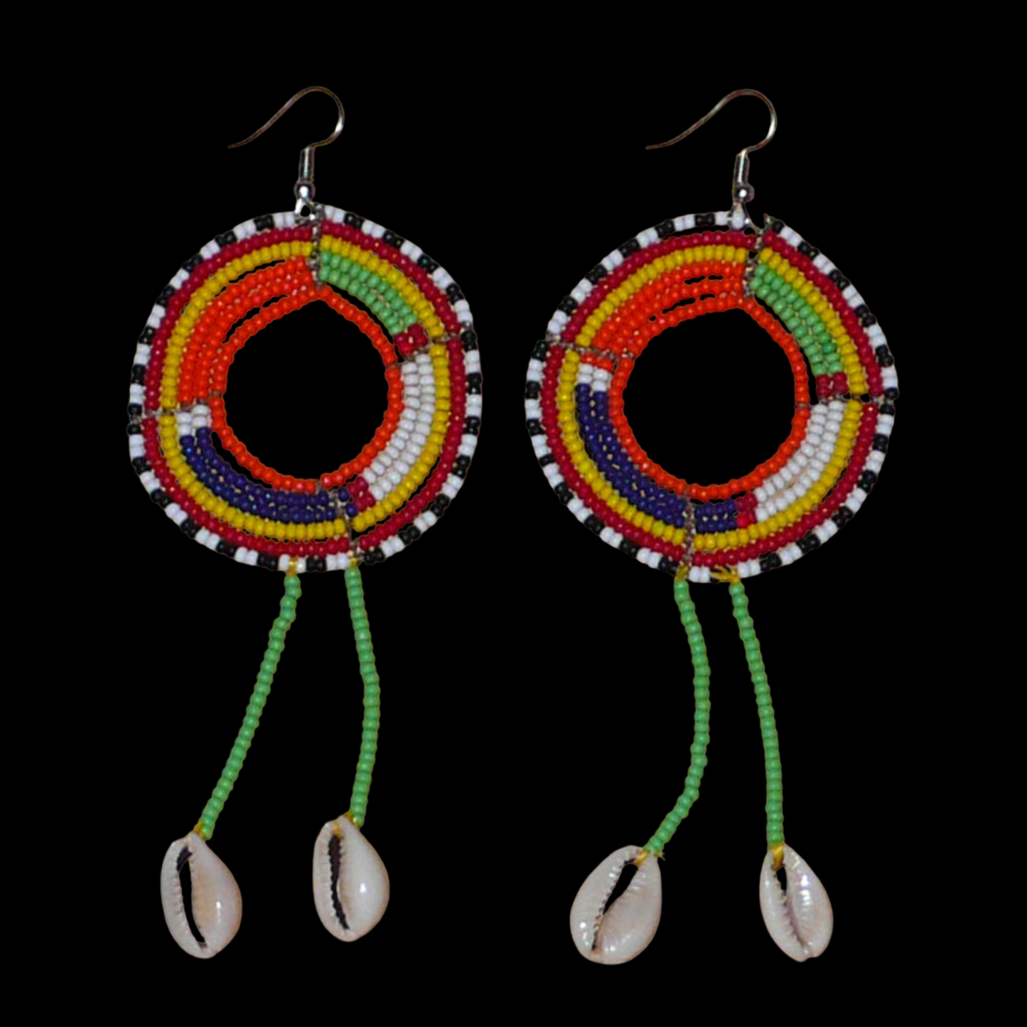 Longues boucles d'oreilles africaines tribales Massai composées de perles de rocaille vertes et multicolores glissées sur une structure ronde en fils de fer et prolongées de franges perlées ornées de coquillages. Elles mesurent 12.5 cm de long et 5 cm de large et se portent sur des oreilles percées.