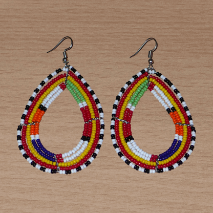 Boucles d'oreilles africaines de tradition tribale Massai composées de perles de rocaille multicolores glissées sur cinq rangées de fils de fer montés en forme de gouttes. Elles mesurent 8.3 cm de long et 4.5 cm de large, et se portent sur des oreilles percées.