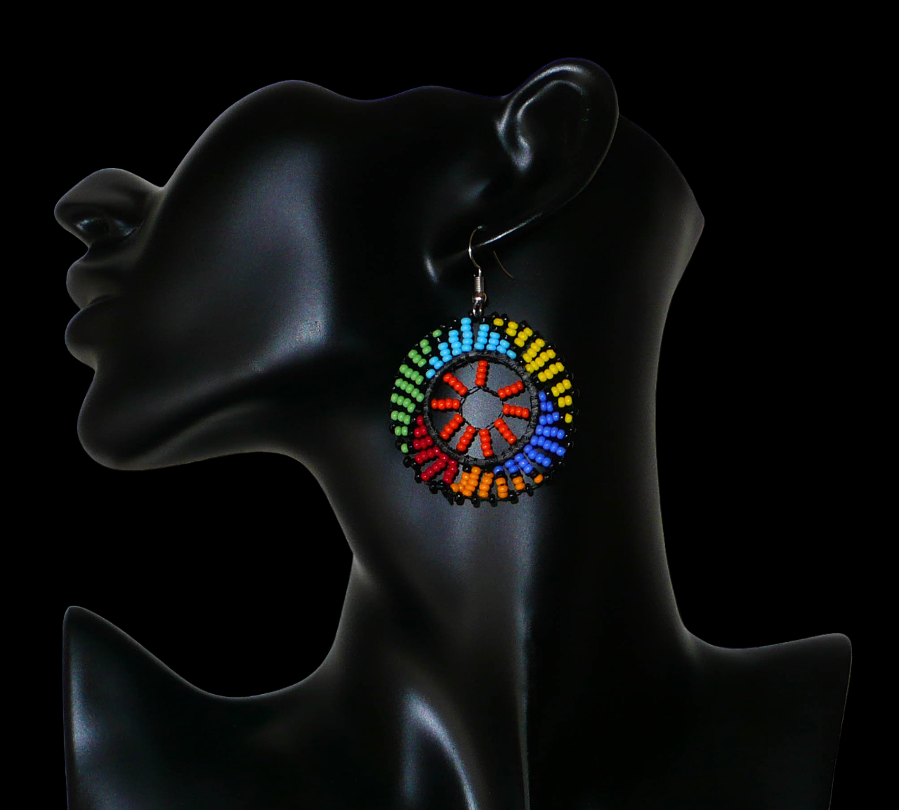 Boucles d'oreilles africaines rondes à motifs ethniques zoulous composées de perles de rocaille orange et multicolores glissées sur des fils de nylon fixés sur des structures circulaires en plastique. Elles mesurent 6 cm de long et 4 cm de large et se portent sur des oreilles percées. Timeless Fineries