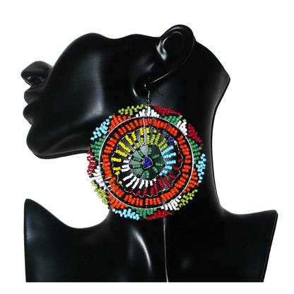 Boucles d'oreilles sud-africaines rondes surdimensionnées à motifs zoulous composées de perles de rocaille multicolores. Longues et larges, elles mesurent 10 cm de long et 8,5 cm de large, et se portent sur des oreilles percées.