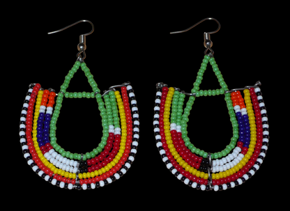 Cette paire de boucles d'oreilles africaines traditionnelles Massai riches en couleurs, de conception artisanale kenyane, apportera une touche tribale à votre look ! Elles se composent de perles de rocaille vertes et multicolores glissées sur des structures géométriques en fils de fer montés en forme d'ancres. Ces boucles d'oreilles mesurent 7.5 cm de long et 4.5 cm de large, et se portent avec des crochets en acier inoxydable sur des oreilles percées.
