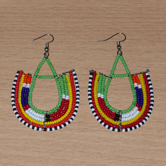 Cette paire de boucles d'oreilles africaines traditionnelles Massai riches en couleurs, de conception artisanale kenyane, apportera une touche tribale à votre look ! Elles se composent de perles de rocaille vertes et multicolores glissées sur des structures géométriques en fils de fer montés en forme d'ancres. Ces boucles d'oreilles mesurent 7.5 cm de long et 4.5 cm de large, et se portent avec des crochets en acier inoxydable sur des oreilles percées.