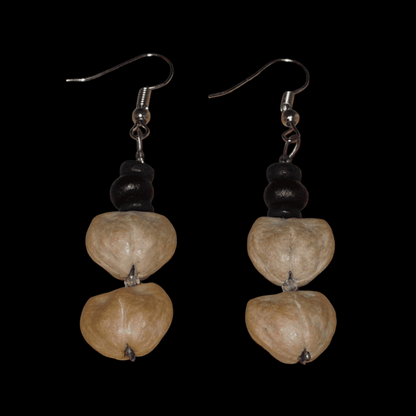 Boucles d'oreilles afro-caribéennes composées de perles de noix de coco et de graines organiques. De taille moyenne, ces boucles d'oreilles aux accents résolument exotiques mesurent 6 cm de long et 1,5 cm de large ; elles se portent avec des crochets en acier inoxydable sur des oreilles percées.