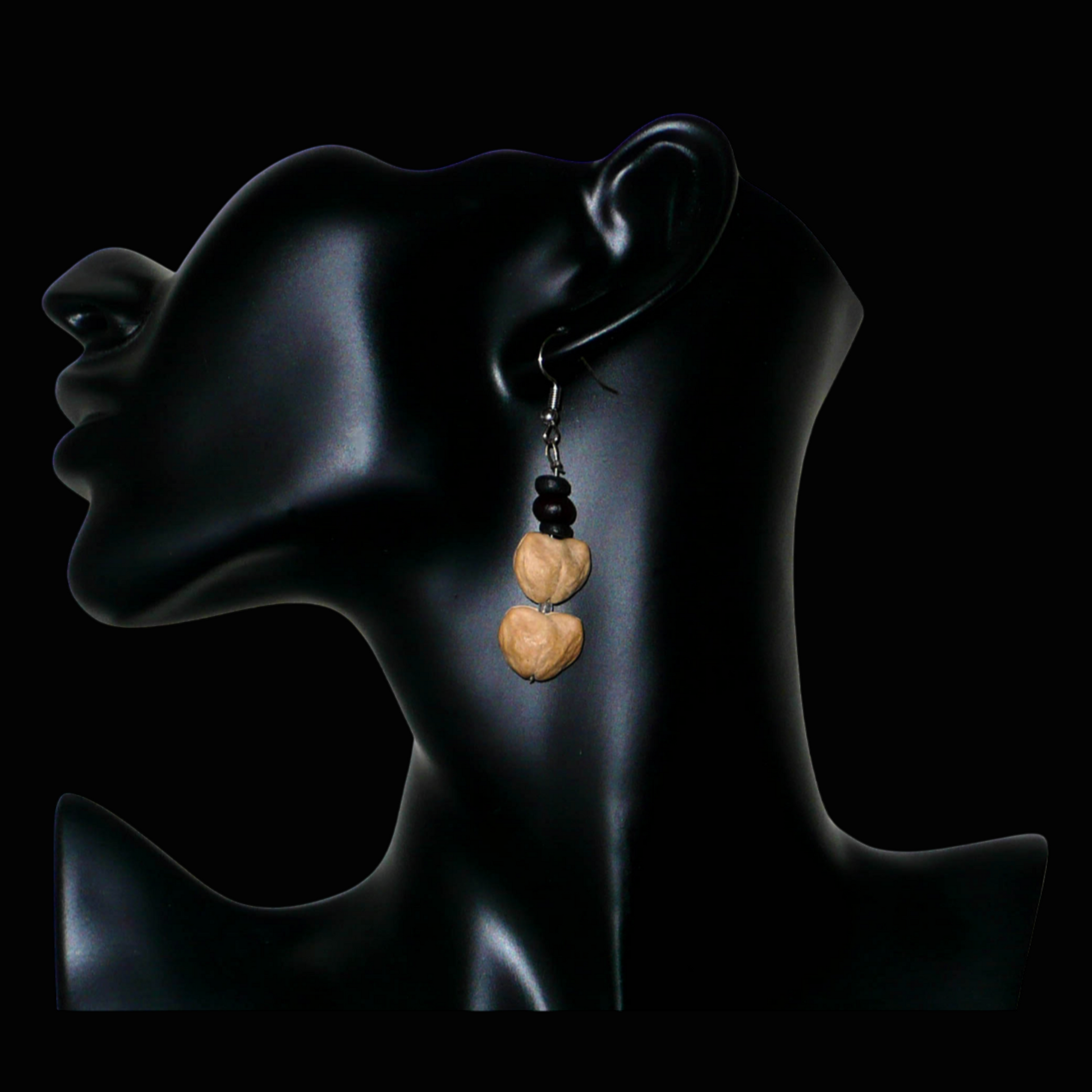 Boucles d'oreilles afro-caribéennes composées de perles de noix de coco et de graines organiques. De taille moyenne, ces boucles d'oreilles aux accents résolument exotiques mesurent 6 cm de long et 1,5 cm de large ; elles se portent avec des crochets en acier inoxydable sur des oreilles percées.
