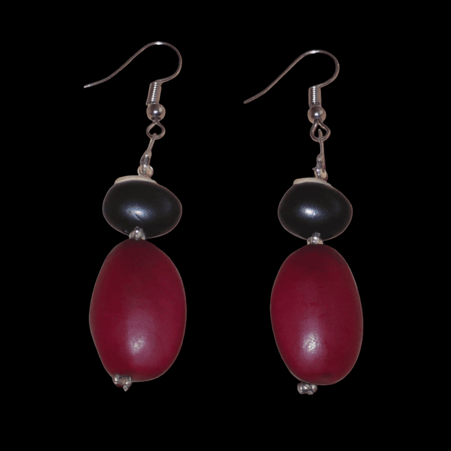 Boucles d'oreilles afro-caribéennes composées de perles et de graines tropicales (graines du Bengale et de Gogan). De taille moyenne, ces boucles d'oreilles mesurent 6 cm de long et 1,5 cm de large ; elles se portent avec des crochets en acier inoxydable sur des oreilles percées.