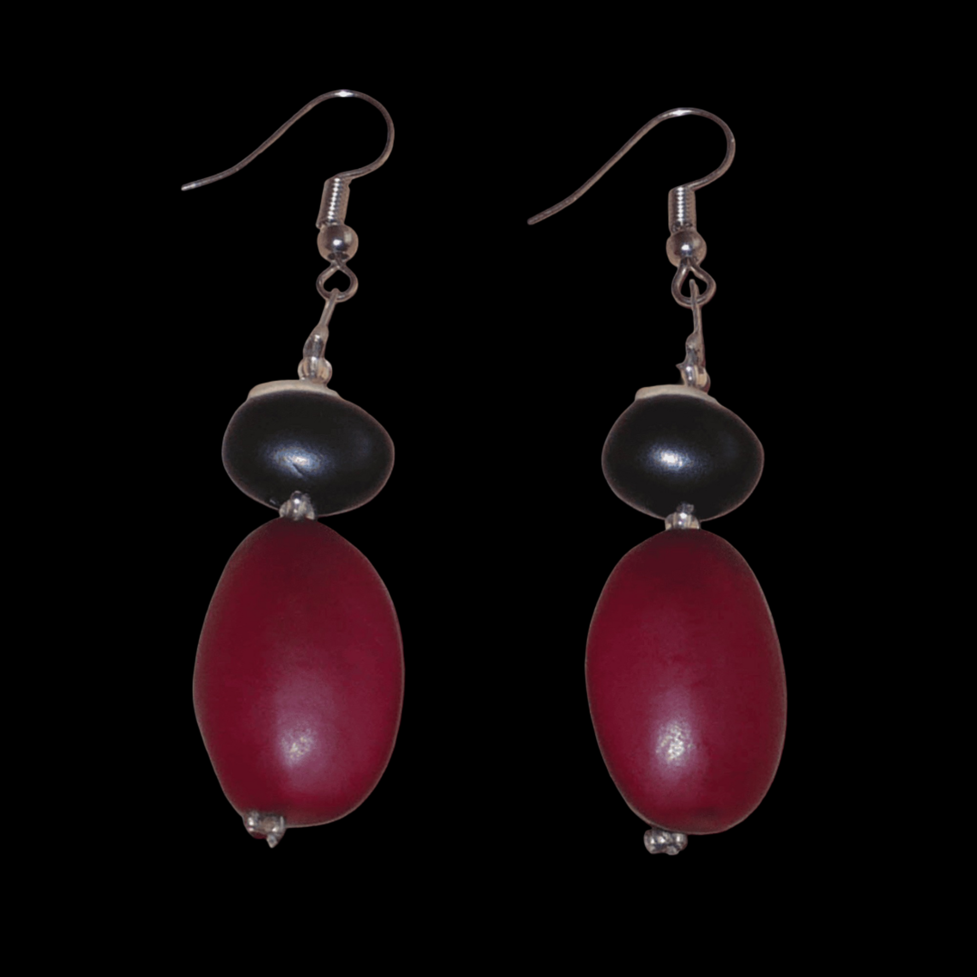 Boucles d'oreilles afro-caribéennes composées de perles et de graines tropicales (graines du Bengale et de Gogan). De taille moyenne, ces boucles d'oreilles mesurent 6 cm de long et 1,5 cm de large ; elles se portent avec des crochets en acier inoxydable sur des oreilles percées.