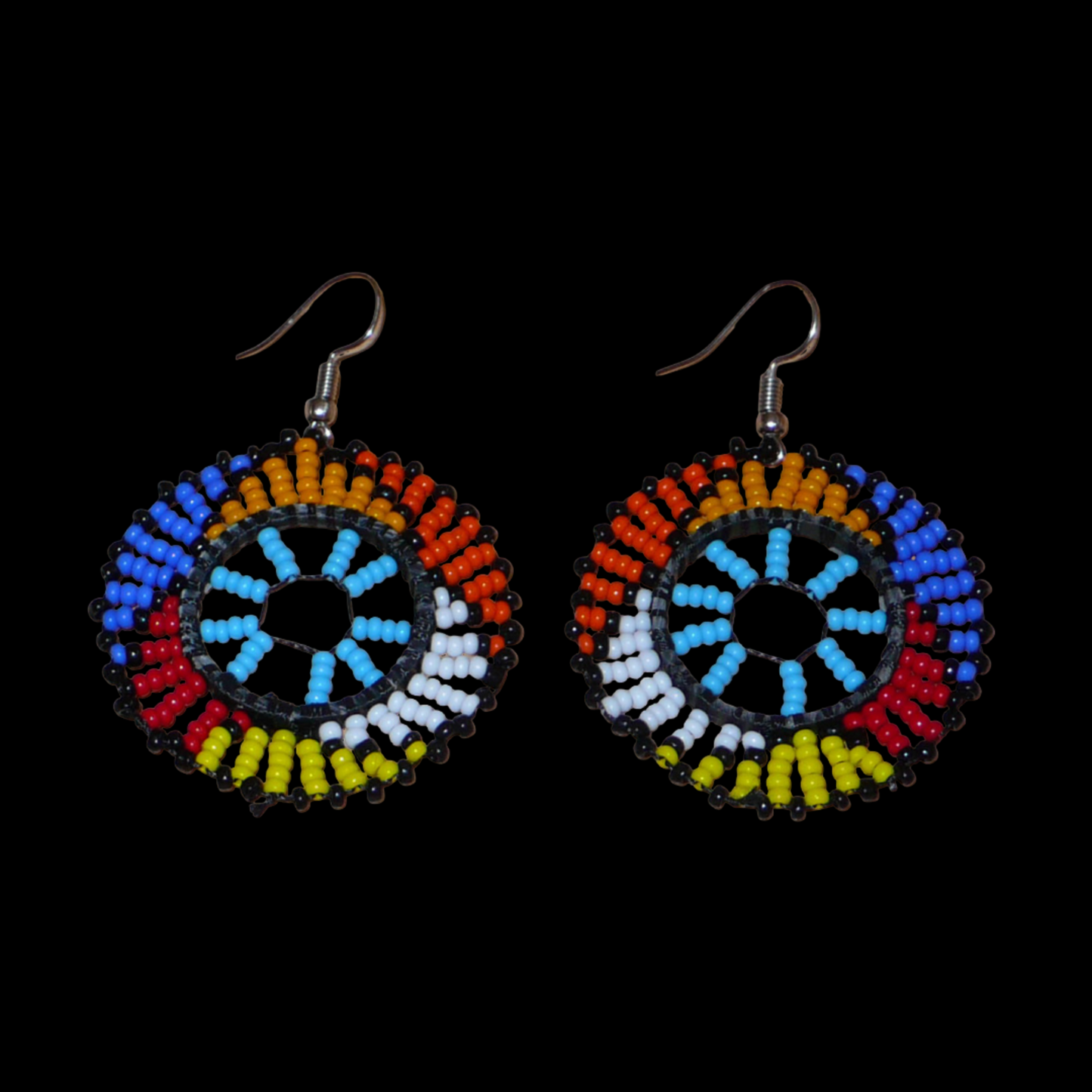 Boucles d'oreilles ethniques rondes à motifs zoulous composées de perles de rocaille bleu ciel et multicolores. De taille moyenne et légères à porter, elles mesurent 6 cm de long et 4 cm de large.