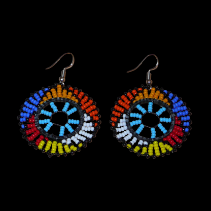 Boucles d'oreilles ethniques rondes à motifs zoulous composées de perles de rocaille bleu ciel et multicolores. De taille moyenne et légères à porter, elles mesurent 6 cm de long et 4 cm de large.