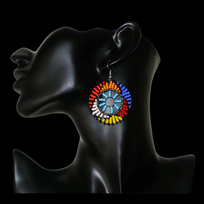Boucles d'oreilles ethniques rondes à motifs zoulous composées de perles de rocaille bleu ciel et multicolores. De taille moyenne et légères à porter, elles mesurent 6 cm de long et 4 cm de large.