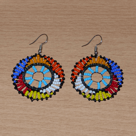 Boucles d'oreilles ethniques rondes à motifs zoulous composées de perles de rocaille bleu ciel et multicolores. De taille moyenne et légères à porter, elles mesurent 6 cm de long et 4 cm de large.