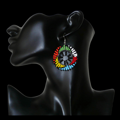 Boucles d'oreilles ethniques rondes à motifs zoulous composées de perles de rocaille noires et multicolores. De taille moyenne et légères à porter, elles mesurent 6 cm de long et 4 cm de large. 
